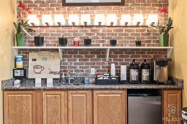 bar featuring sink, dark stone countertops, and stainless steel fridge