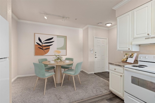 dining area with ornamental molding, track lighting, and light hardwood / wood-style flooring