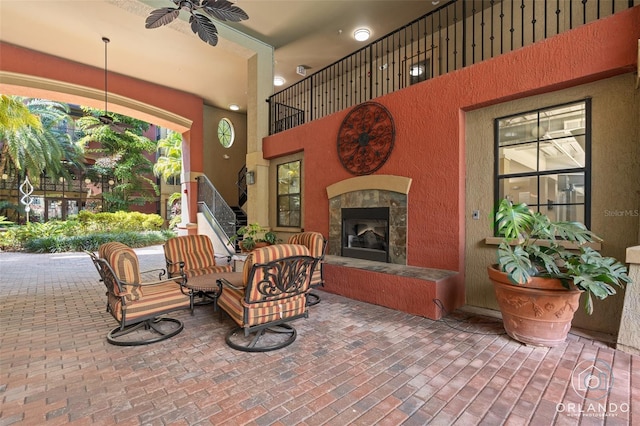 view of patio / terrace with ceiling fan and a tile fireplace