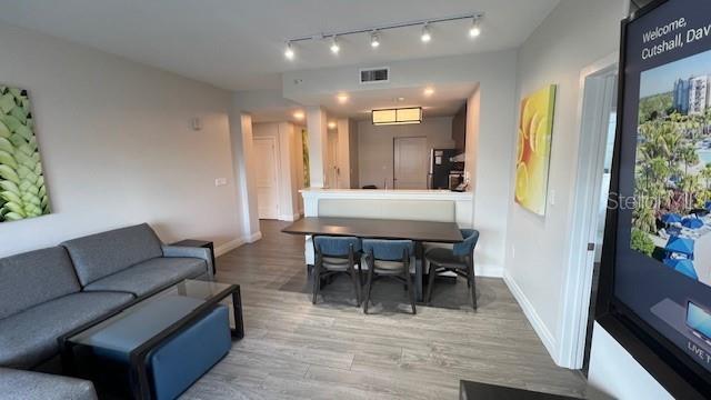 living room with light hardwood / wood-style floors and rail lighting