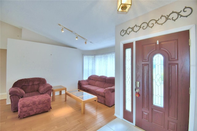 entrance foyer with light wood-type flooring and vaulted ceiling