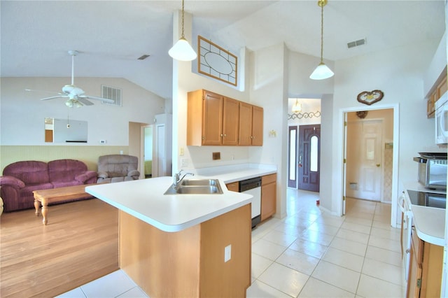 kitchen featuring sink, kitchen peninsula, decorative light fixtures, dishwashing machine, and light tile patterned flooring