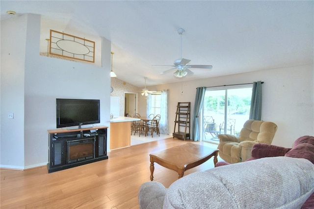 living room with vaulted ceiling, light hardwood / wood-style flooring, and ceiling fan