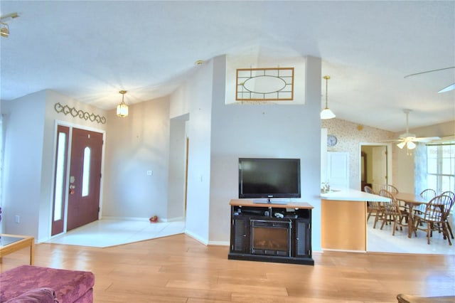 entrance foyer featuring ceiling fan, lofted ceiling, and light wood-type flooring