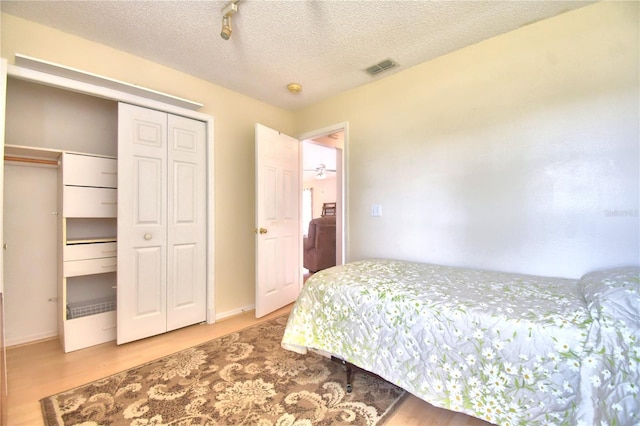 bedroom with wood-type flooring and a textured ceiling