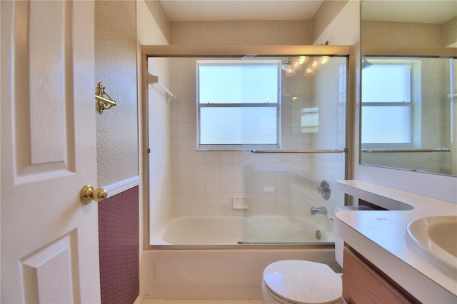 full bathroom featuring vanity, bath / shower combo with glass door, and toilet