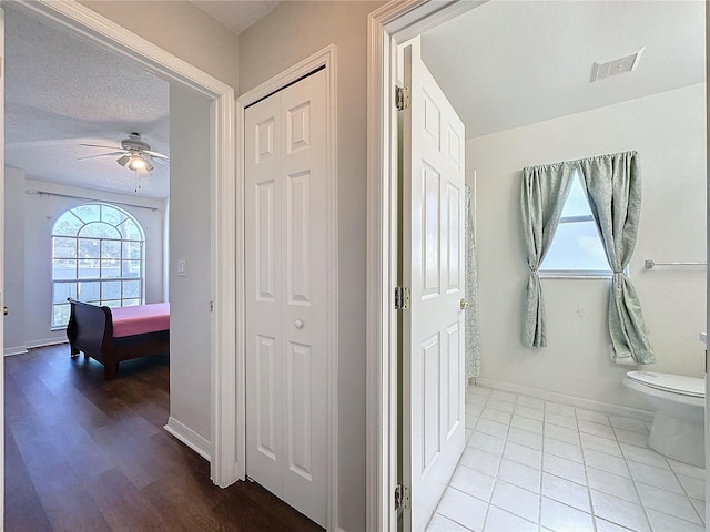 hall featuring light hardwood / wood-style flooring and a textured ceiling