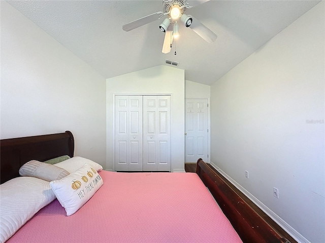 bedroom with ceiling fan, lofted ceiling, and a closet