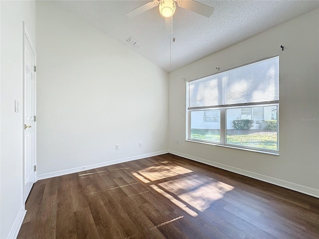 spare room with a textured ceiling, vaulted ceiling, ceiling fan, and dark wood-type flooring