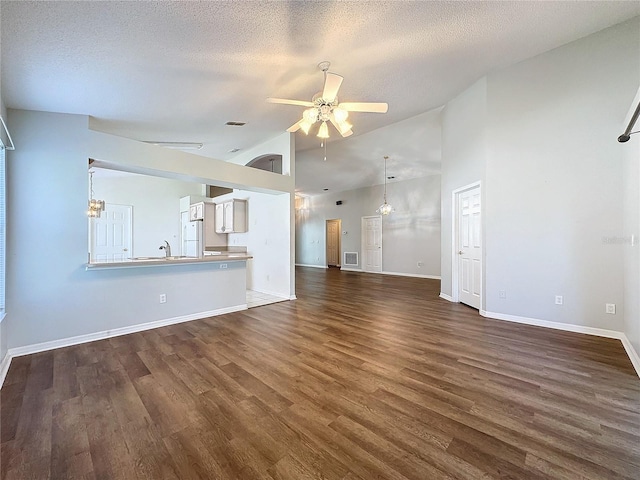 unfurnished living room with ceiling fan, dark hardwood / wood-style flooring, a textured ceiling, and high vaulted ceiling