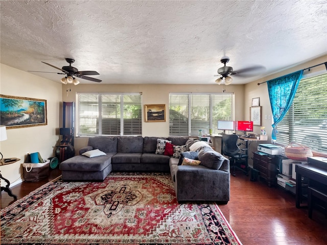 living room featuring a healthy amount of sunlight, dark hardwood / wood-style floors, ceiling fan, and a textured ceiling