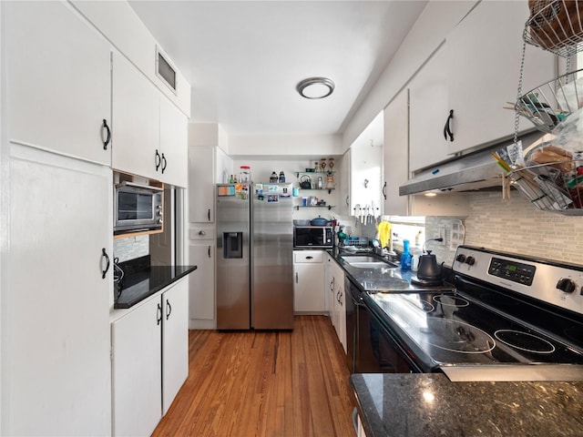 kitchen with backsplash, light hardwood / wood-style flooring, stainless steel appliances, and white cabinets