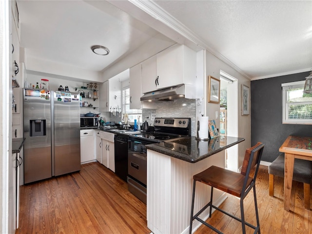 kitchen with white cabinets, light wood-type flooring, stainless steel appliances, and a wealth of natural light