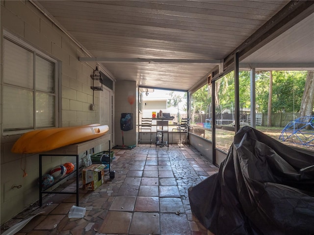 sunroom with plenty of natural light, vaulted ceiling, and wooden ceiling