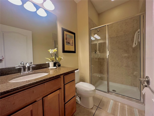 bathroom featuring vanity, toilet, a shower with door, and tile patterned floors