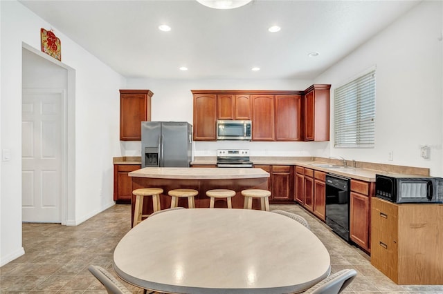 kitchen with a center island, sink, a breakfast bar, and black appliances