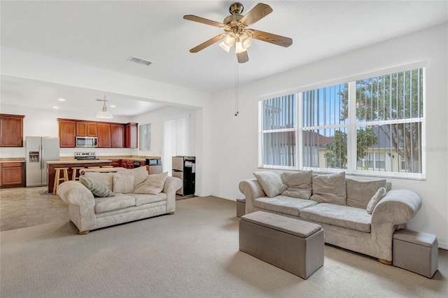 living room with light colored carpet and ceiling fan