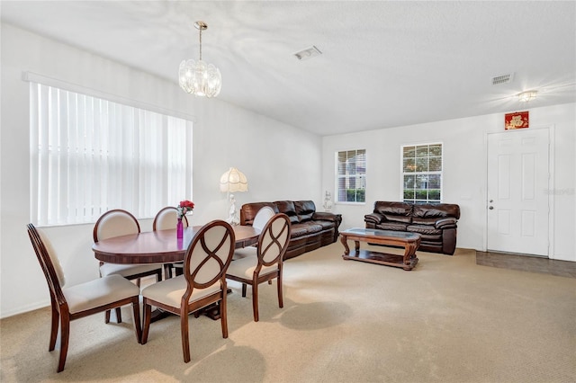 dining room featuring a chandelier and carpet flooring