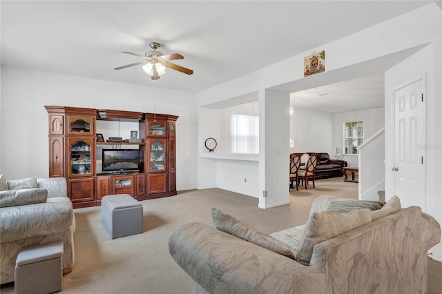 carpeted living room with ceiling fan