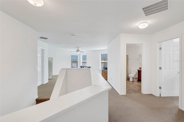 corridor with carpet floors and a textured ceiling