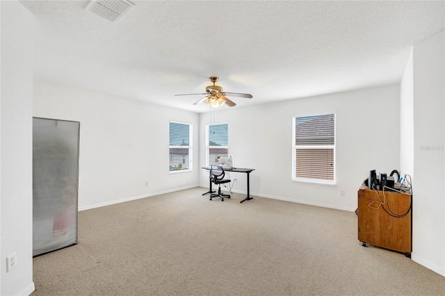 carpeted empty room with ceiling fan and a textured ceiling