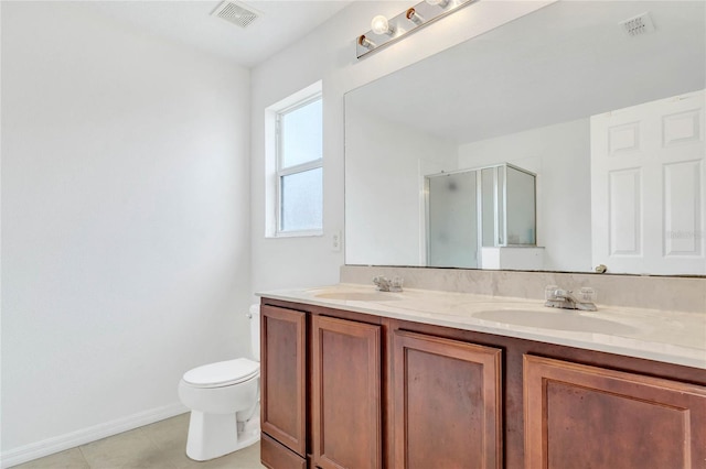 bathroom featuring tile patterned flooring, vanity, a shower with shower door, and toilet