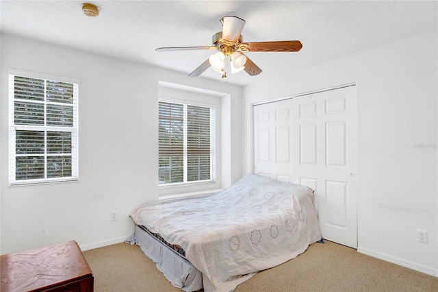 carpeted bedroom with a closet and ceiling fan