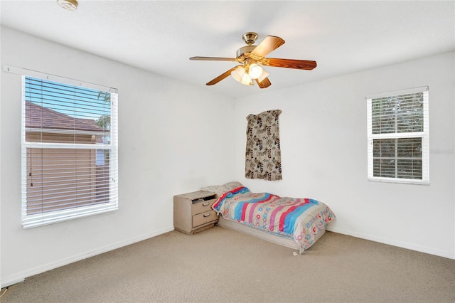 carpeted bedroom with multiple windows and ceiling fan