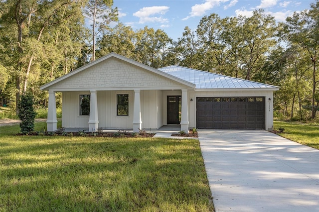 view of front of house with a front yard, a garage, and covered porch