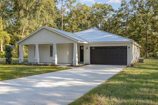 view of front facade featuring covered porch, a front yard, and a garage