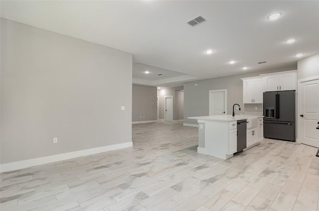 kitchen featuring light hardwood / wood-style floors, white cabinets, a center island with sink, fridge with ice dispenser, and stainless steel dishwasher