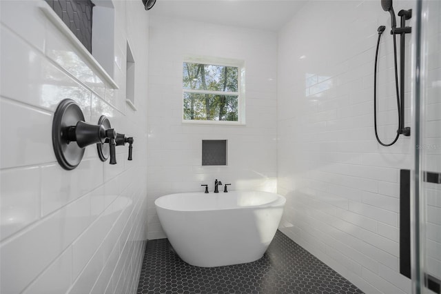 bathroom with tile walls, tile patterned floors, and separate shower and tub