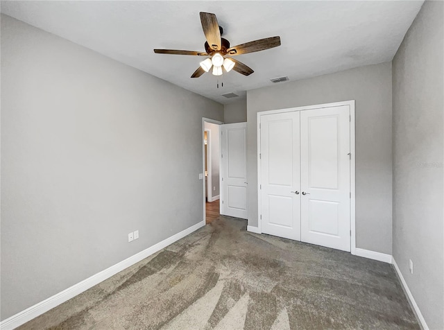 unfurnished bedroom with a closet, ceiling fan, and dark carpet