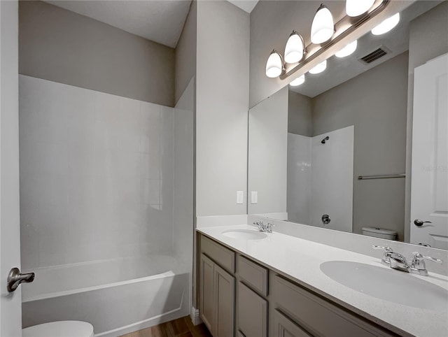 full bathroom featuring hardwood / wood-style floors, double sink, oversized vanity, shower / bath combination, and toilet