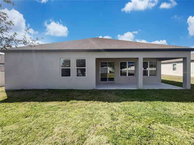 back of property featuring a patio and a lawn