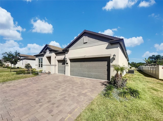 view of front of property with a front yard, a garage, and central air condition unit