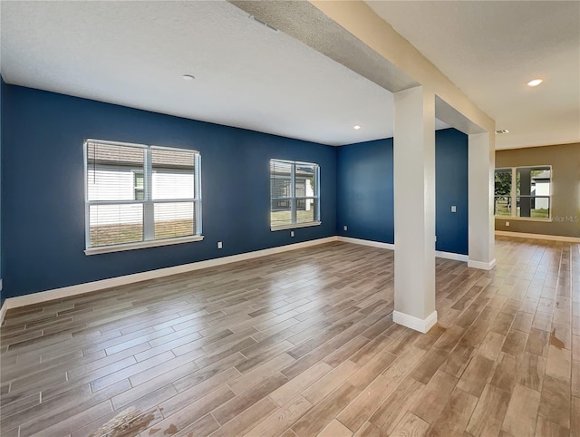 empty room featuring a healthy amount of sunlight and light wood-type flooring