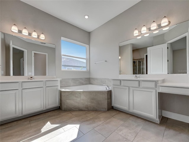 bathroom featuring vanity, a relaxing tiled bath, and tile flooring