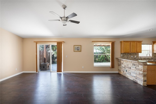 interior space featuring backsplash, a healthy amount of sunlight, dark hardwood / wood-style flooring, and ceiling fan