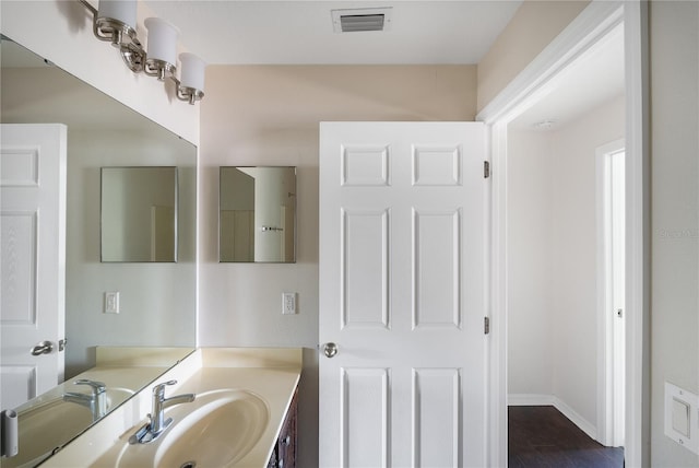 bathroom featuring hardwood / wood-style floors and large vanity