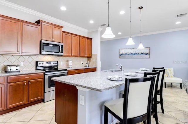 kitchen featuring stainless steel appliances, a kitchen island with sink, light tile floors, and decorative light fixtures