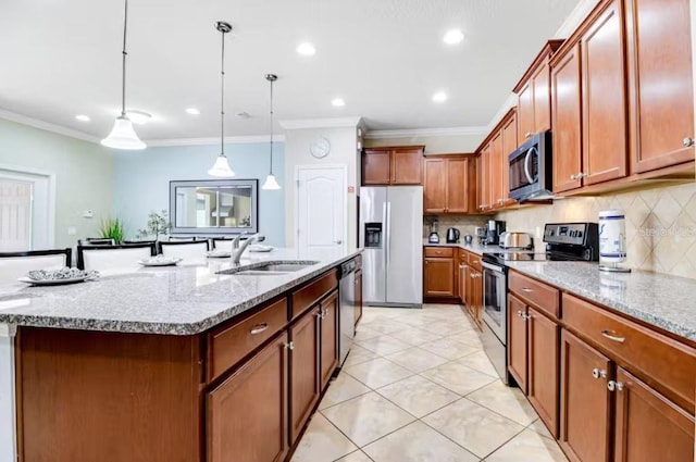 kitchen featuring hanging light fixtures, tasteful backsplash, an island with sink, appliances with stainless steel finishes, and sink