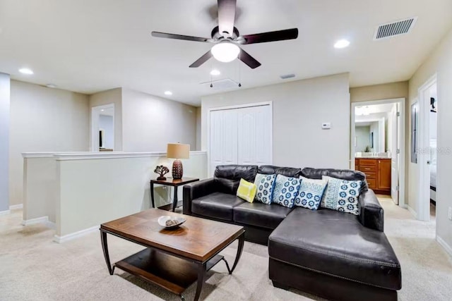 carpeted living room with ceiling fan