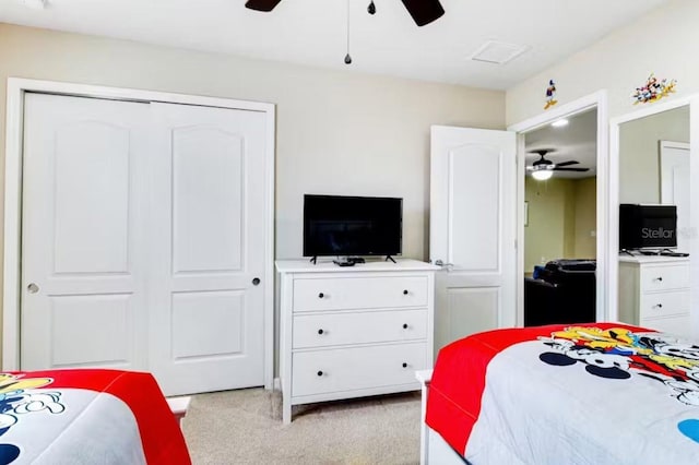 bedroom with ceiling fan, a closet, and light colored carpet