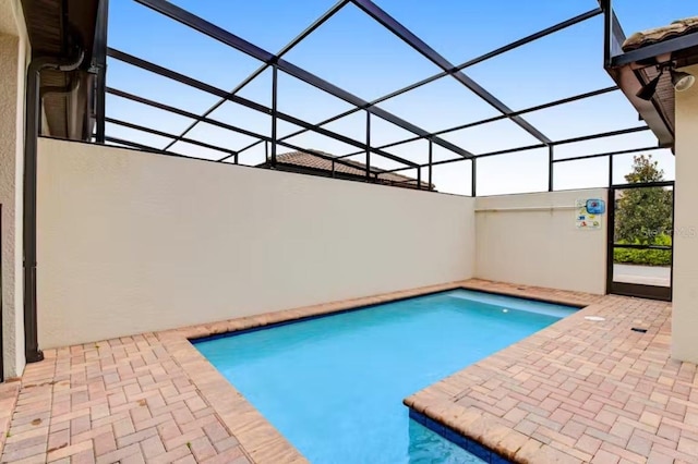 view of swimming pool featuring a patio area and a lanai