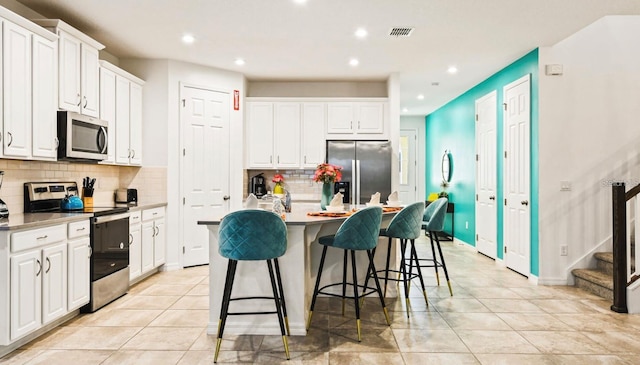 kitchen featuring white cabinets, tasteful backsplash, and stainless steel appliances