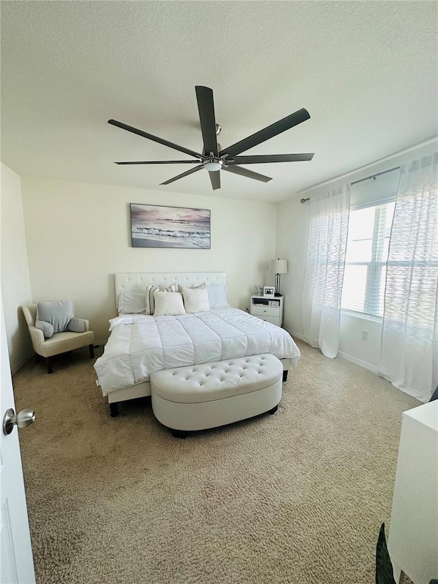 bedroom with a textured ceiling, ceiling fan, and carpet flooring