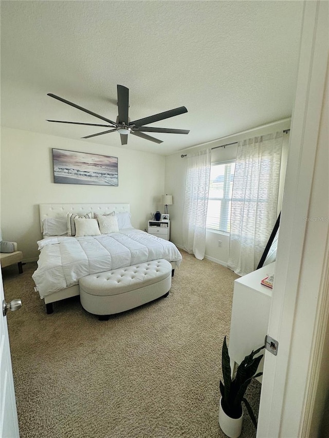 bedroom featuring ceiling fan, carpet flooring, and a textured ceiling