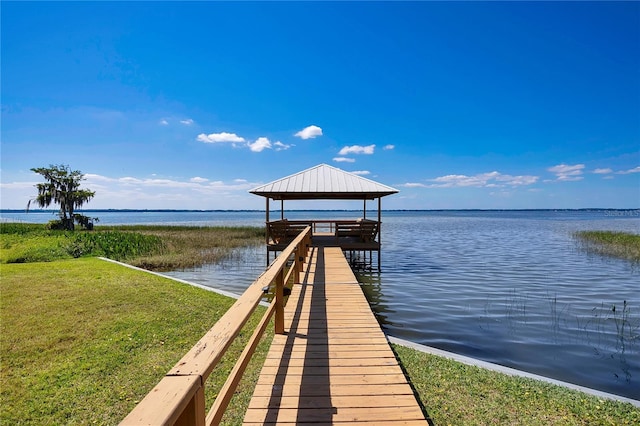 dock area with a water view, a yard, and a gazebo