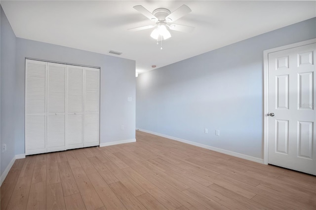 unfurnished bedroom with light wood-style flooring, a closet, visible vents, and baseboards